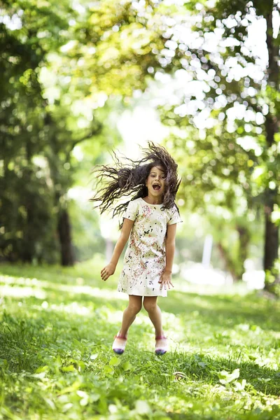 Hermosa chica saltando sonriendo en el parque —  Fotos de Stock