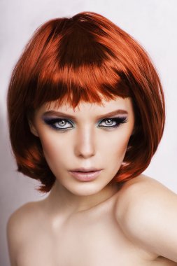 Beyaz zemin üzerine kırmızı saçlı güzel şık kadın.