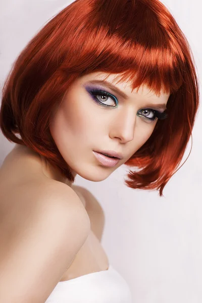 Hermosa mujer elegante con el pelo rojo sobre fondo blanco . — Foto de Stock