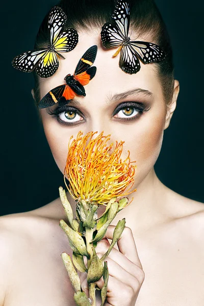 검은 바탕에 이국적인 꽃과 나비 아름 다운 젊은 여자의 초상화 — 스톡 사진