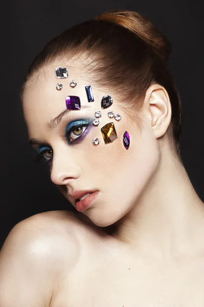 Portrait of beautiful woman with creative make up with crystals on black background made in studio — Stock Photo, Image