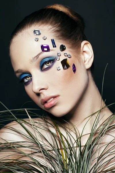 Portrait of beautiful woman with creative make up with crystals on black background made in studio — Stock Photo, Image
