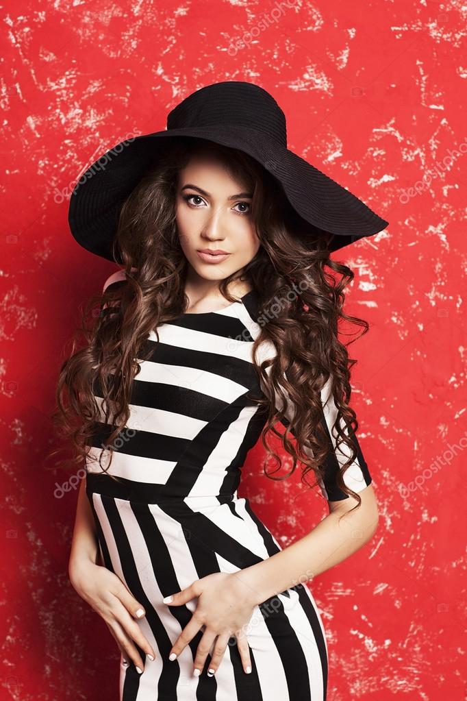 Beautiful Young Woman With Long Curly Hair In Black Hat And