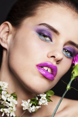 Pembe ve beyaz çiçekler ile profesyonel makyaj güzel genç kadın