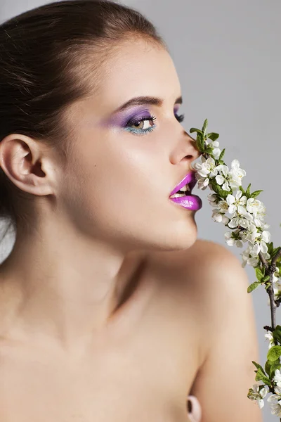 Beautiful young woman with professional make up with pink and white flowers — Stock Photo, Image