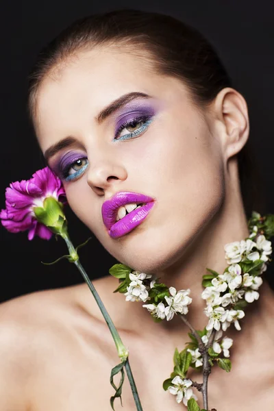 Hermosa joven con maquillaje profesional con flores rosas y blancas — Foto de Stock