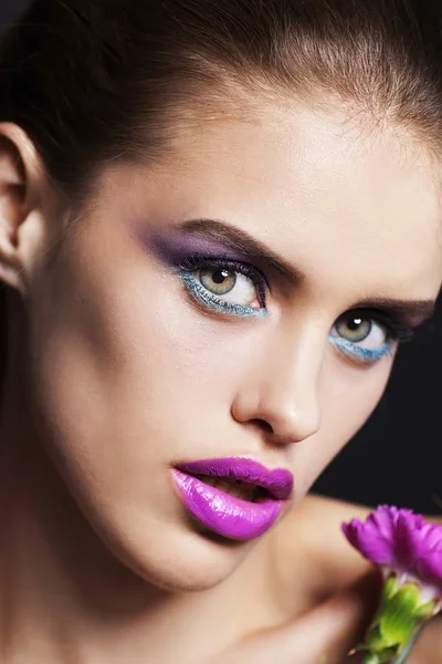 Hermosa joven con maquillaje profesional con flores rosas y blancas — Foto de Stock