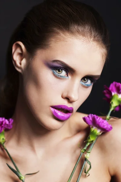 Beautiful young woman with professional make up with pink and white flowers — Stock Photo, Image