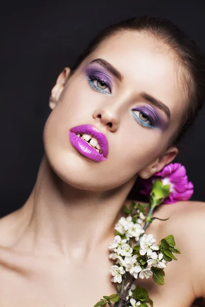 Hermosa joven con maquillaje profesional con flores rosas y blancas — Foto de Stock