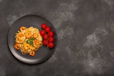 Gri taşlı arka plan manzaralı karidesli spagetti. kopyalama alanı. Metin için boş alan