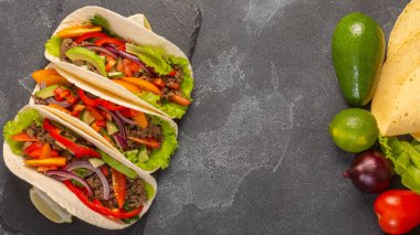 Meksika tacoları, taco malzemeleri, üst manzara, gri taştan bir arka plan. Boşluğu kopyala