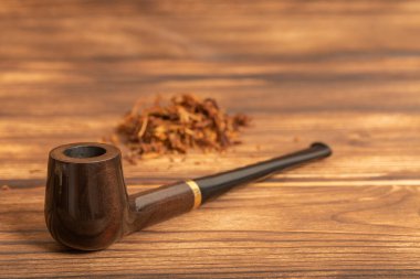 Ahşap arka planda sigara piposu ve tütün.