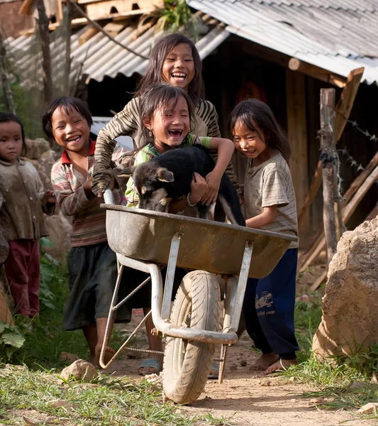 LAO CAI, VIETNAM, 12 marzo 2016 Gruppo Lao Cai di bambini che giocano all'aperto, con un'auto semplice Immagine Stock