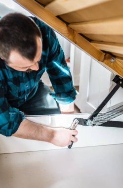 Adam evde mobilya anahtarı kullanarak yatak kaldırma mekanizması kuruyor. DIY Montaj Mobilyaları.