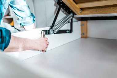 Adam evde mobilya anahtarı kullanarak yatak kaldırma mekanizması kuruyor. DIY Montaj Mobilyaları.