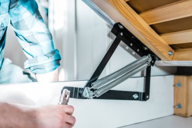 Adam evde mobilya anahtarı kullanarak yatak kaldırma mekanizması kuruyor. DIY Montaj Mobilyaları.