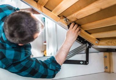 Adam evde mobilya anahtarı kullanarak yatak kaldırma mekanizması kuruyor. DIY Montaj Mobilyaları.