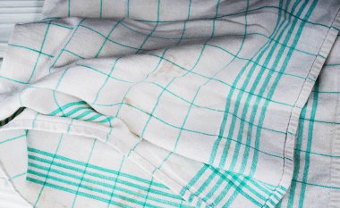 Tahta bir masanın üzerinde lekeler olan doğal pamuklu mutfak havlusuna zarar vermiş. Mutfak konsepti.