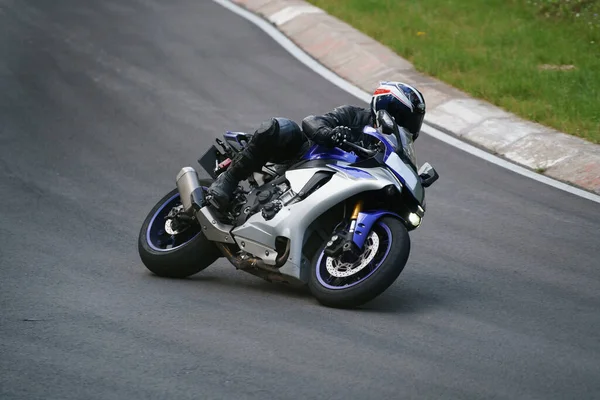 アスファルトの道路でバイクに乗る男 黒のスポーツバイクで黒のスーツでオートバイ — ストック写真