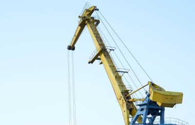 Kargo limanındaki sarı vinç kömürü çeviriyor. Sanayi sahnesi