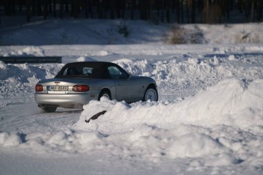 05-02-2021 RIga, Letonya. Aşırı sürüş, araba yumuşak karın üzerinde hızla hareket ediyor ve bir kar püskürtüsü oluşturuyor.