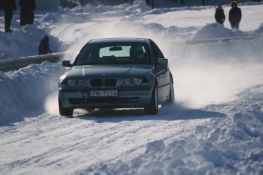 05-02-2021 RIga, Letonya. Aşırı sürüş, araba yumuşak karın üzerinde hızla hareket ediyor ve bir kar püskürtüsü oluşturuyor.