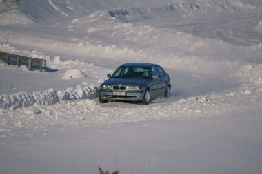 05-02-2021 RIga, Letonya. Aşırı sürüş, araba yumuşak karın üzerinde hızla hareket ediyor ve bir kar püskürtüsü oluşturuyor.