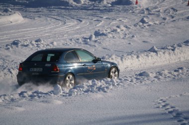05-02-2021 RIga, Letonya. Aşırı sürüş, araba yumuşak karın üzerinde hızla hareket ediyor ve bir kar püskürtüsü oluşturuyor.