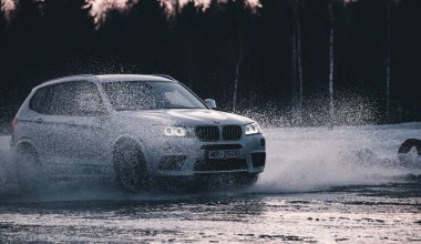 Riga, Letonya 10 Şubat 2021 - Suyun üzerinde süzülen, arabadan fışkıran. Ön görünüm.