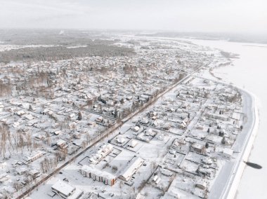 Karlı ağaçlarla kaplı kış ormanlarındaki donmuş nehrin havadan görünüşü. Kış doğası, nehir ve ağaçlarla kaplı beyaz kar manzarası.