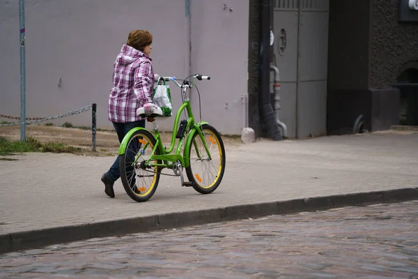 2020 Riga Latvia Woman Green Bike Walks Road — Zdjęcie stockowe