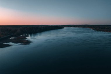 Beyaz Rusya veya günbatımında Rusya'nın Avrupa kısmı sonbahar nehir manzara Panoraması. Güneş Parlatıcı üzerinde mavi su göl veya nehir, gündoğumu. Doğa güneşli sabah. Riverside'da portakal yapraklar koruyu