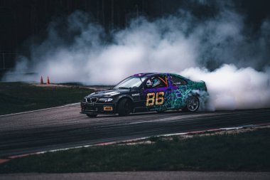 01-05-2021 Riga Latvia. Blurred of image diffusion race drift car with lots of smoke from burning tires on speed track