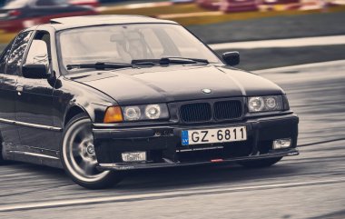 Siyah arabanın önden görünüşü hızlı gidiyor..