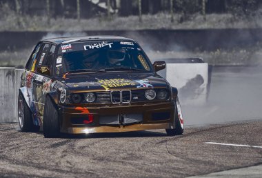 21-05-2021 Riga, Letonya arabası asfalt yarış pistinde sürükleniyor çok fazla duman ve hareket bulanıklığı olan araba..