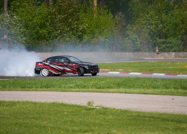 2021ラトビアのリガは 多くの煙とアスファルトのレーストラックに漂流車 モーションブラードリフト車 — ストック写真