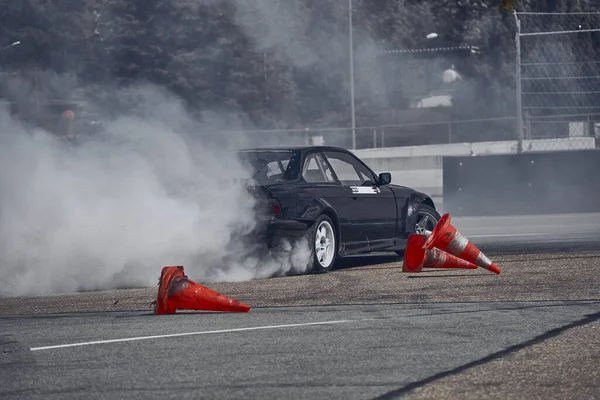 2021ラトビアのリガは 多くの煙とアスファルトのレーストラックに漂流車 モーションブラードリフト車 — ストック写真