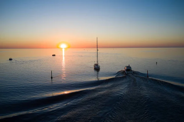 10-06-2021 Jurmala, Latvia Little boat sails to meet sunset in the sea.