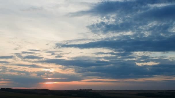 Bewegende wolken boven veld een zonsondergang, timelapse. — Stockvideo