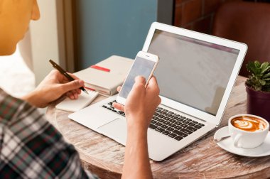 Smartphone ve tablete yazma dizüstü kullanarak iş adamı