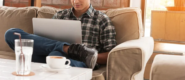 Empresário usando laptop no sofá no café com uma xícara de co — Fotografia de Stock