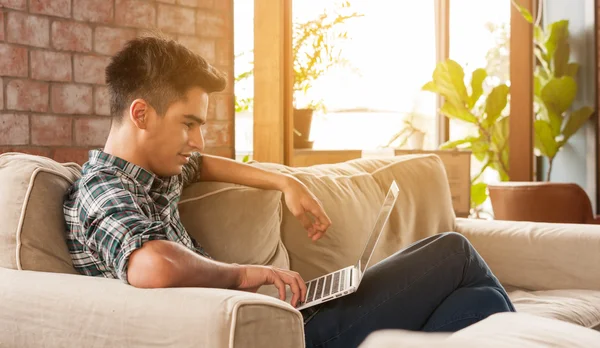 Zakenman met behulp van laptop op sofa in koffie shop — Stockfoto