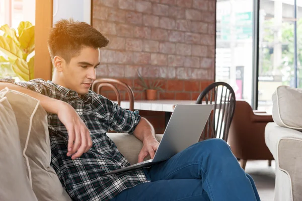 Üzletember használ a laptop a kávézóban kanapé — Stock Fotó