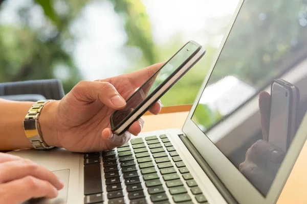 Man met smartphone met laptop, afbeelding scène met venster licht — Stockfoto