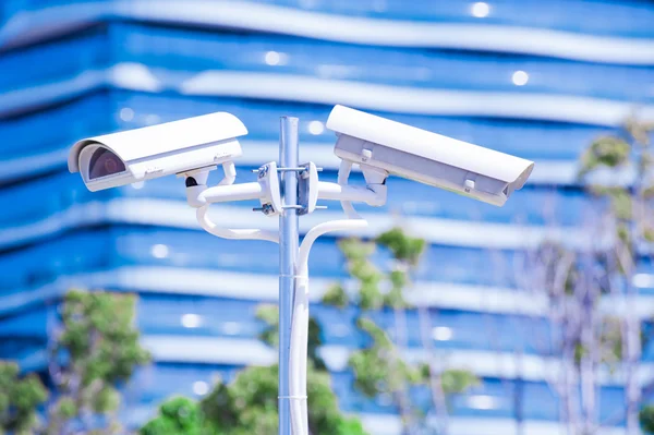 Cámara CCTV o vigilancia operando con edificio azul en bac — Foto de Stock