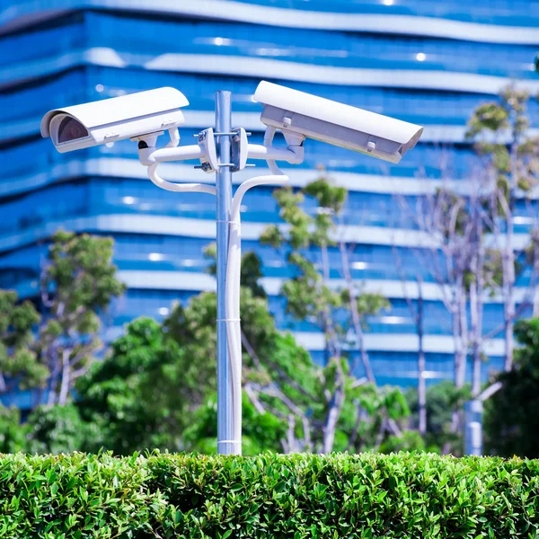 Cámara CCTV o vigilancia operando con edificio azul y pa —  Fotos de Stock