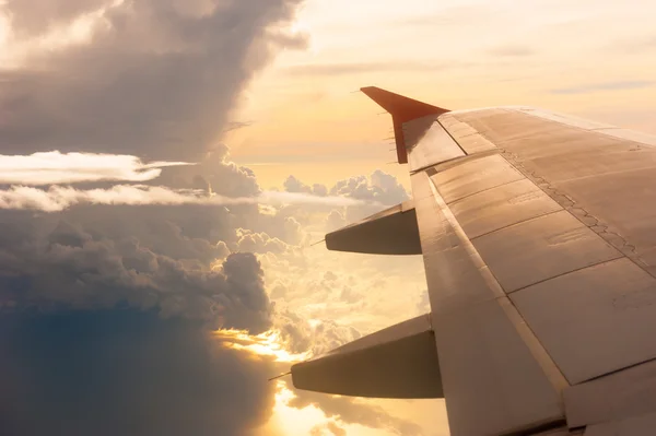 Wing of the plane on golden sky background — Stock Photo, Image