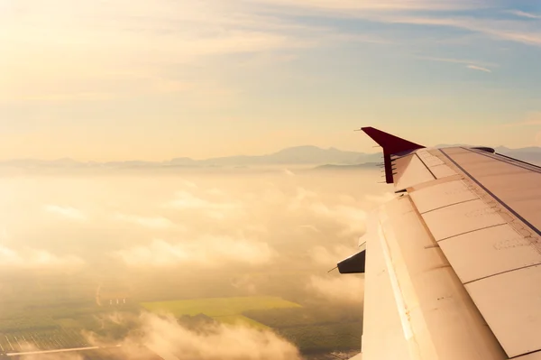 Wing of the plane on golden sky background — Stock Photo, Image