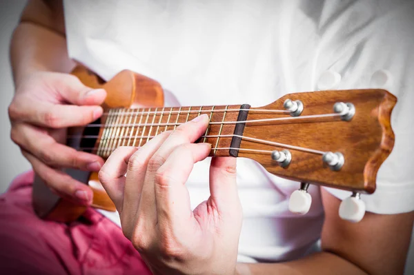 Mão tocando ukulele, instrumento de corda pequena — Fotografia de Stock