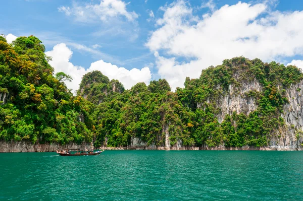 stock image Beautiful scene of boat on green clear water with rock mountain 